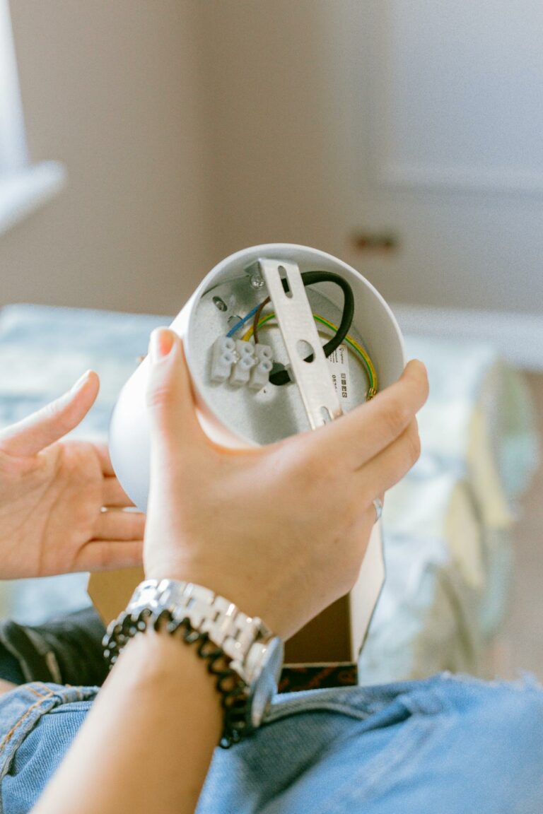 Close-up of a woman assembling a light fixture, showcasing home improvement and DIY skills.